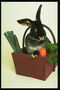 Сидящий кролик в корзине с овощами