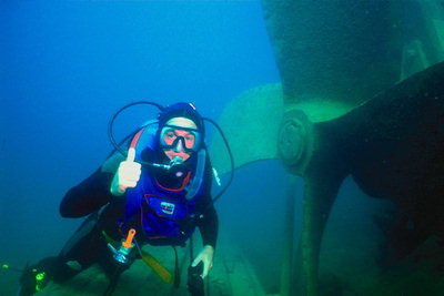 Человек с аквалангом возле лопастей мотора утонувшего корабля