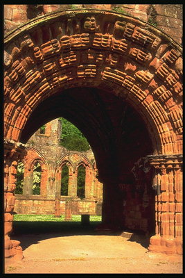 Украшенная каменная арка открывает вид на часть старинного замка
