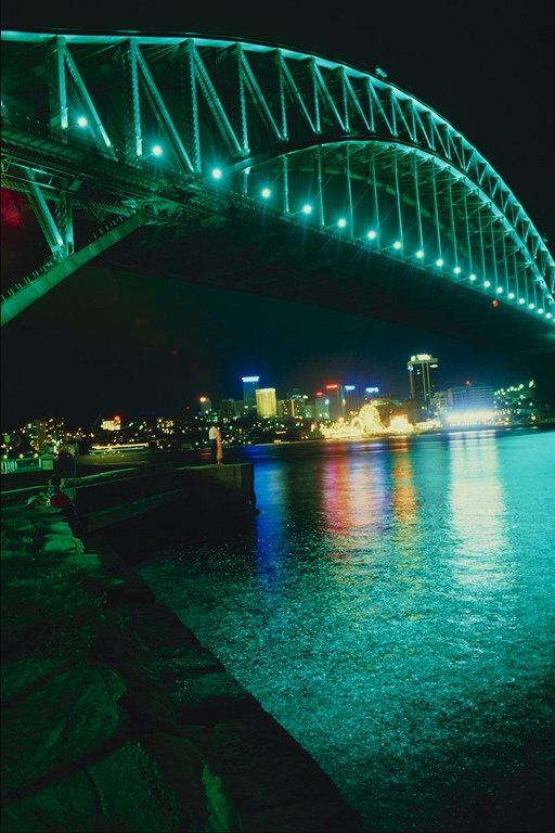 Отображение огней ночного города на воде у моста