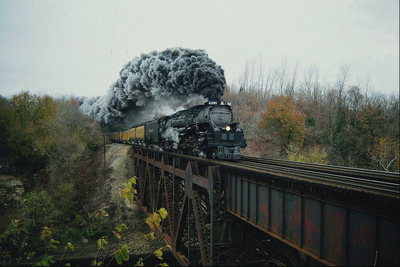 Паровоз в дыму проезжает по старом мосту