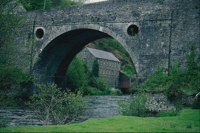 Каменный дом у реки и мост в форме арочного выреза