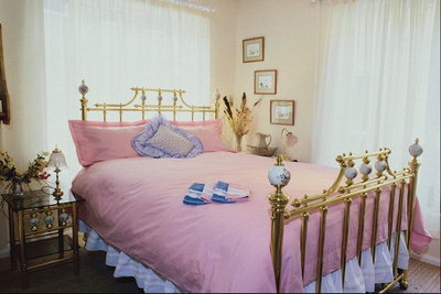 Кровать с металлическим каркасом. Розовый тон покрывала