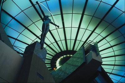 Выставочный центр. Статуя под стеклянным потолком с темно-синего и бирюзового стекла