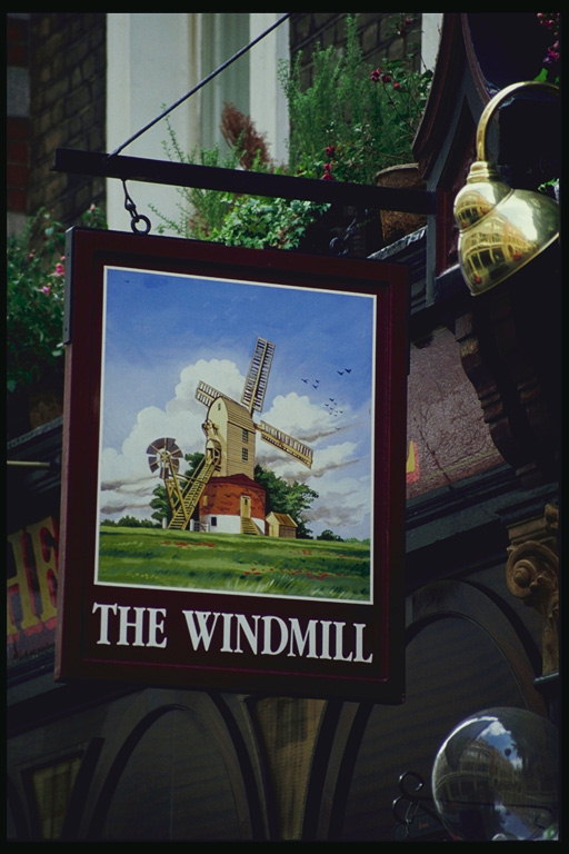 Mill. Figura Mills në sfond të qiellit të kaltër dhe reve