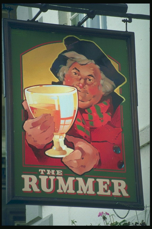 Picture a man with a glass of alcohol at the pub sign