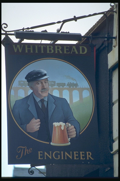 Un homme avec une chope de bière à un chemin de fer