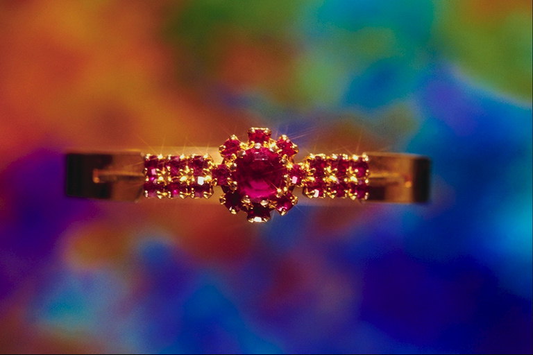 Ring with ruby. Two series of small and large stones in the center