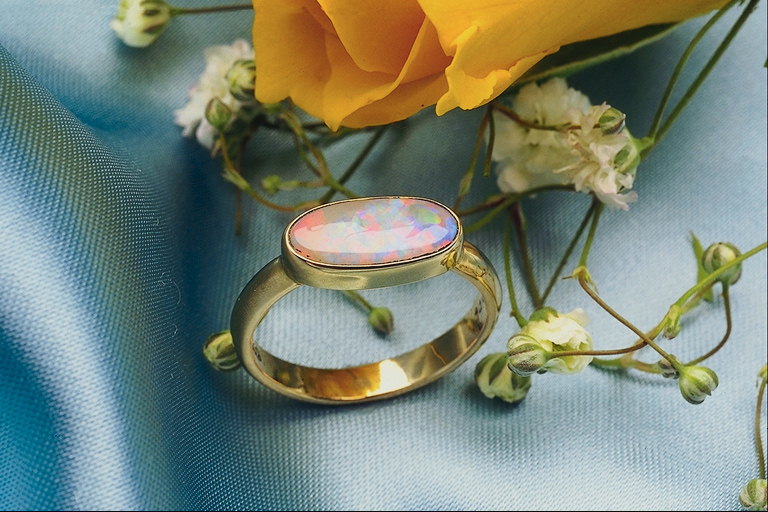 Ring kanssa vaaleanpunainen kivi kanssa lila ja vihreä pisteitä