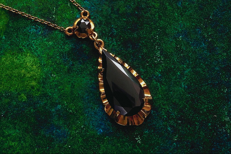 Pendant in the form of drops of brown stone borders with wavy shape