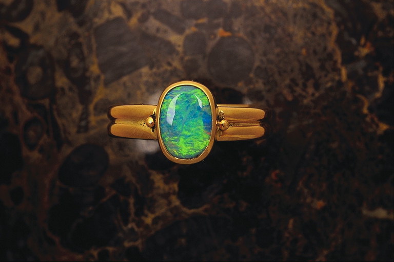 טבעת עם משטח בולטות, האבן א מוארת בצבעים כחול ירוק