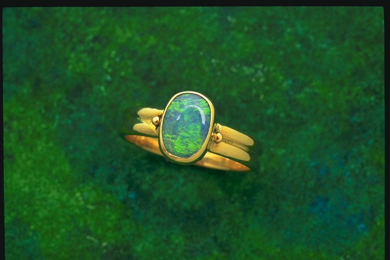 Prstan z dvema udarcev in zelenkasto-modre barve kamna