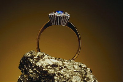 Prsten s safirom okružen malim jasnim kamenje