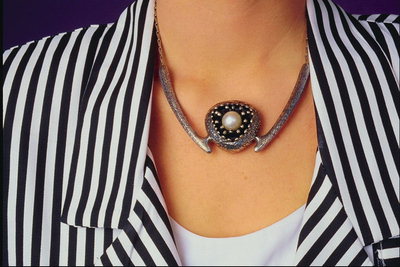 Halsband med metall och pärlor i centrum
