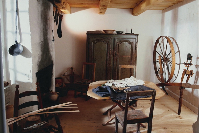 Um quarto com um velho guarda-roupa e acessórios para a fabricação de fios