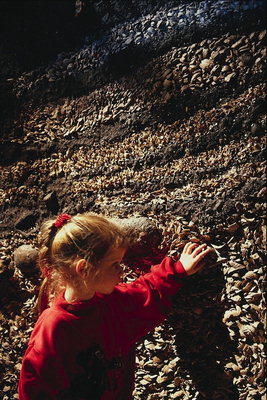 Flickan på väggen med små stenar