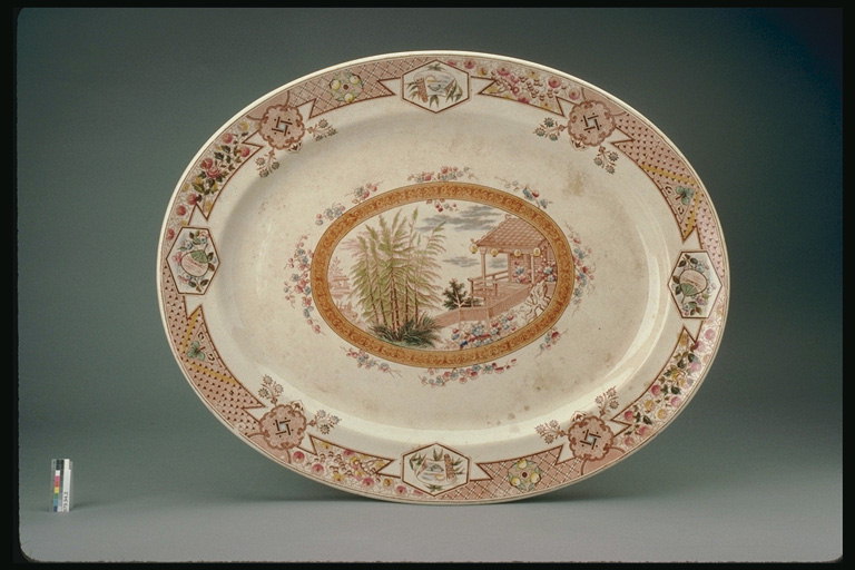 Овальной формы тарелка с рисунком крыльца и деревьев у дома