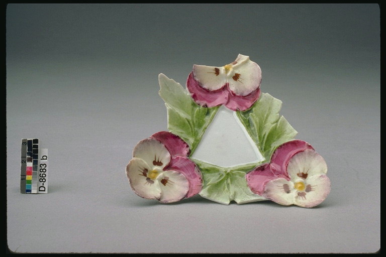 Plate forma triangular, con moldagem de flores e follas de violetas