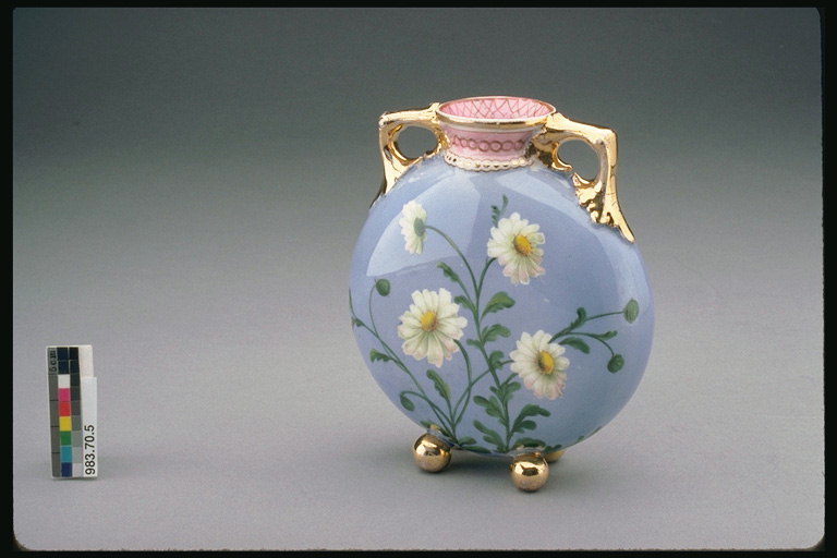 Vaza sa drškom zlatno smeđa. Bijela daisies na plavoj pozadini