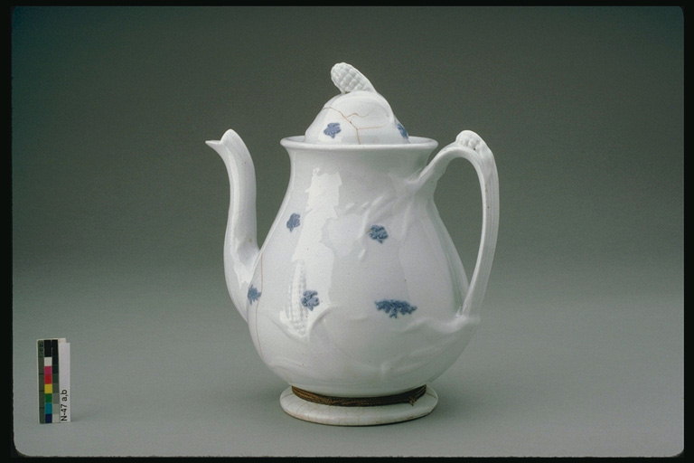 Teapot với một mô hình nhỏ màu xanh trên tường
