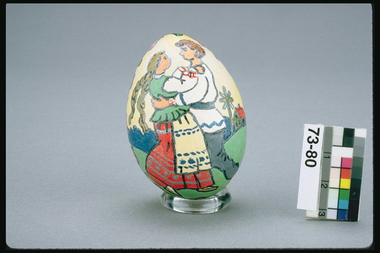 Egg patterned on the popular theme. Girls and boys in traditional costumes