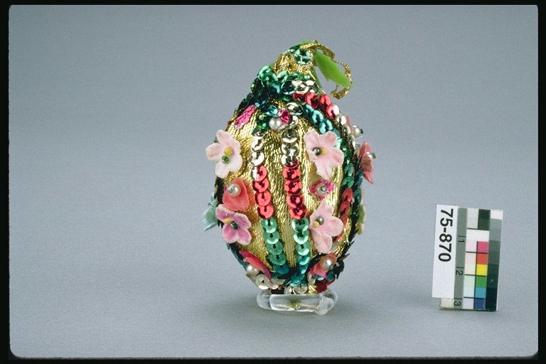 Het ei is versierd met kralen en kunstbloemen