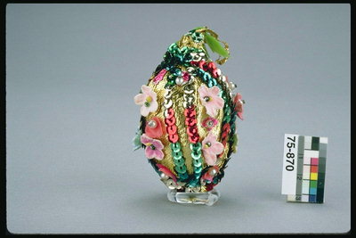 The egg er dekorert med perler og kunstige blomster