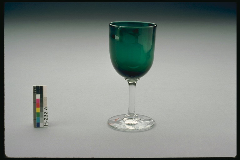 Un got de vidre verd fosc amb una tija transparent