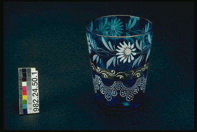Glas med blå glas. White daisies og brun kviste