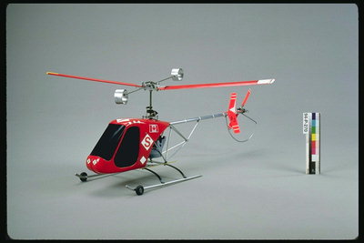 A vrtulník s pohyblivými červenými koly a čepelí