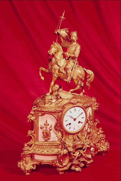 Часы с украшением с ветвей, символов и статуи всадника