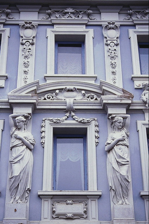 Facaden af bygningen i lilla nuancer. Colon som en kvinde, de arch