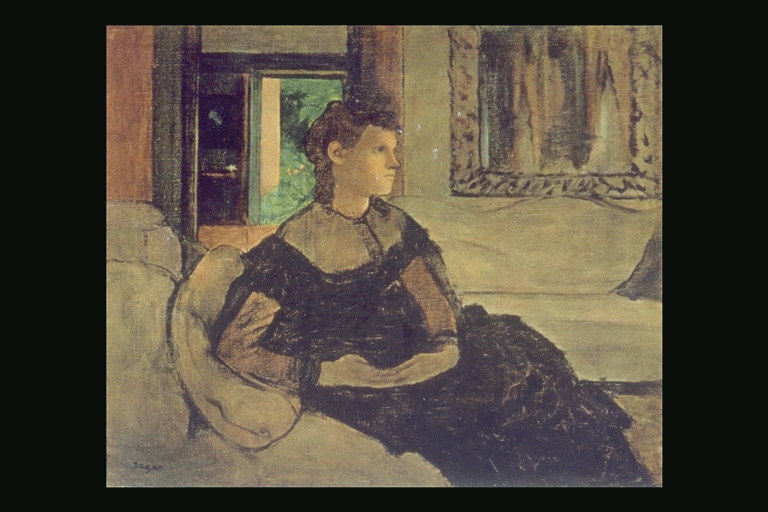 Een jonge vrouw in een donkere kleding in de stoel