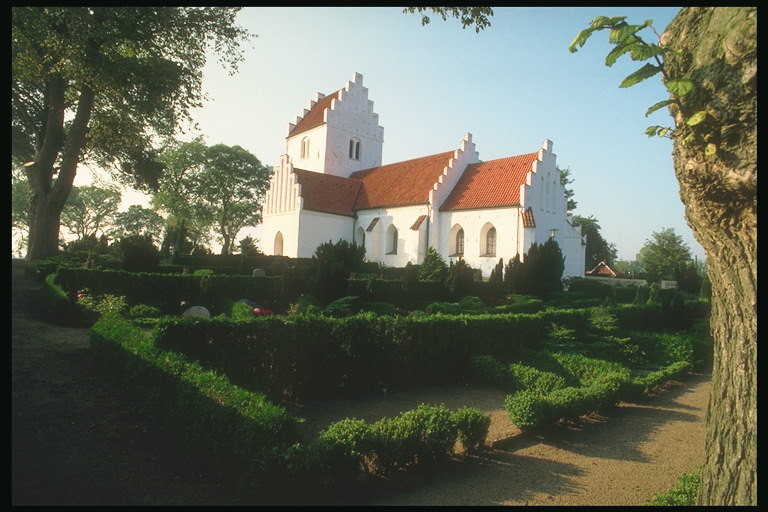 Dom s bielymi stenami a strechou s oranžovou dlaždice