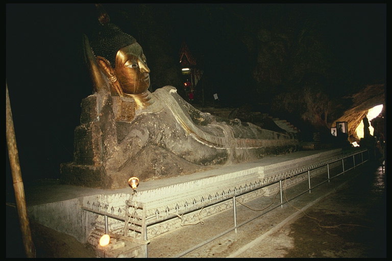 Tomb. Statue af metal hoved og krop med en sten