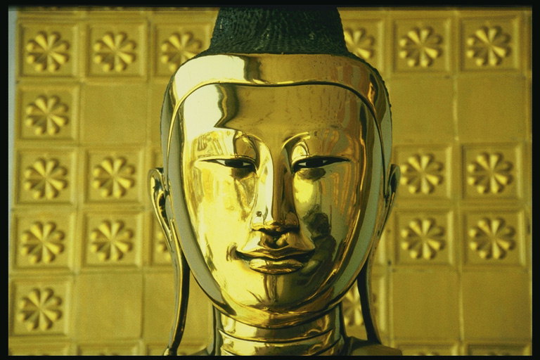 Голова человека из блестящего метала золотого цвета