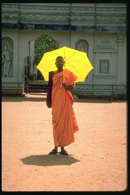 Një burrë me një të verdhë të ndritshme ombrellėn