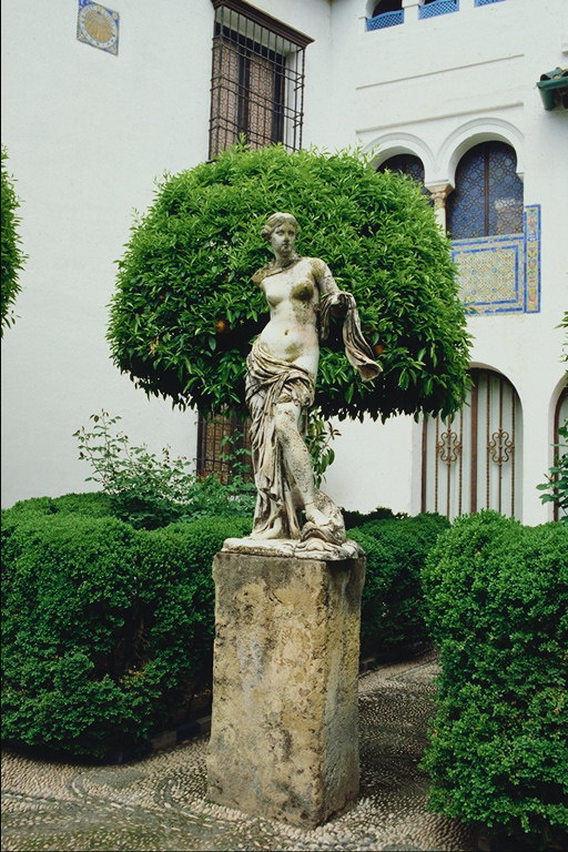 Statyn av en tjej i trädgården