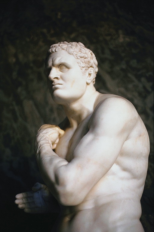 Het standbeeld van een man met een naakte torso en een lint op de hand