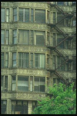 Вид многоэтажного жилого дома с балконами и чеканкой внешних стен