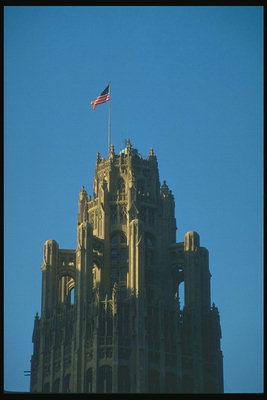 Американский флаг гордо развевается на высоком старинном замке