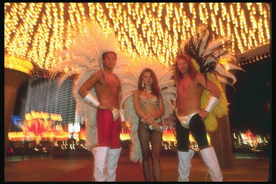 Карнавал в Лас-Вегасе. Мужчины с оголённым торсом с крыльями ангела, девушка в бикини с крыльями ангела