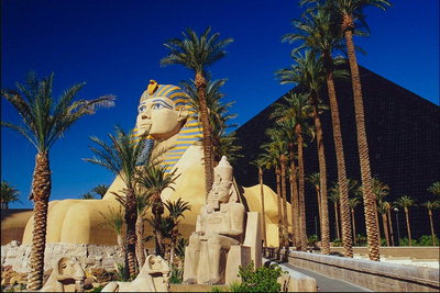 The statue of the mythical ancient Egyptian god among the palms