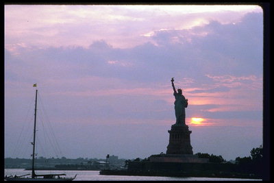 Статуя свободы на фоне восходящего солнца