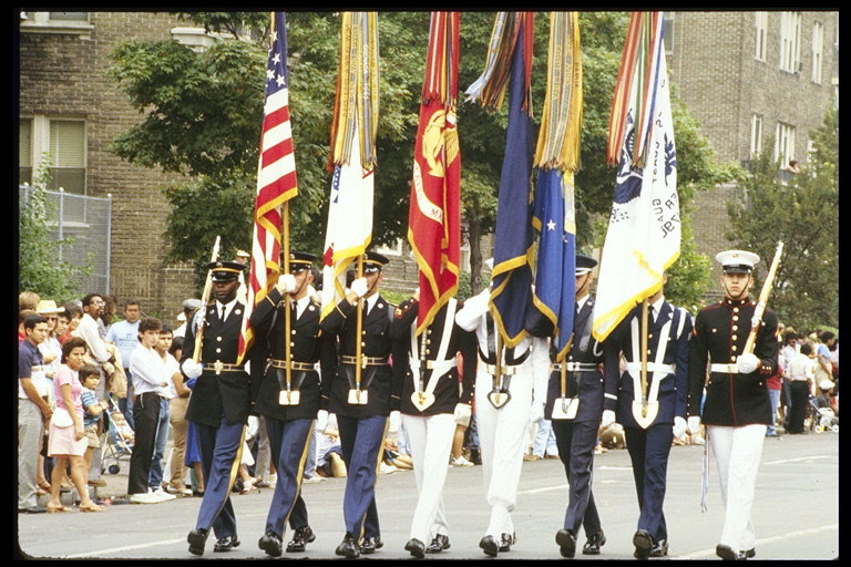 Группа солдат идущая на площади с флагами в руках