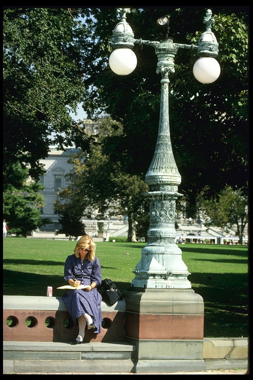 Сквер парка. Читающая женщина на лавочке