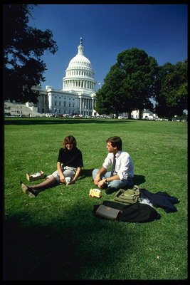 Мужчина и женщина сидят на траве в парке