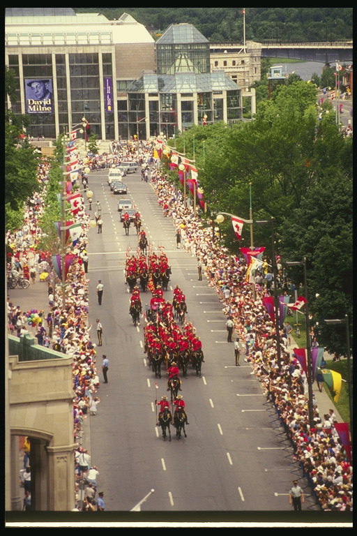 Ant arklio joja procesija į rūmus. Apie keliu šventė pakabinti Kanados vėliava
