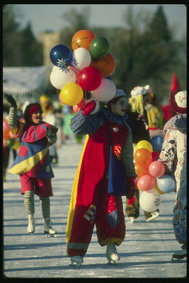 Clowns at a festival with colorful balloons create a holiday atmosphere