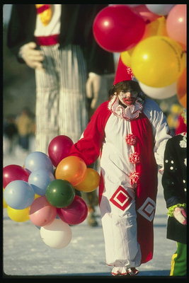 Девушка выступает в роли клоуна. В костюме национальных цветов Канады с воздушными шарами